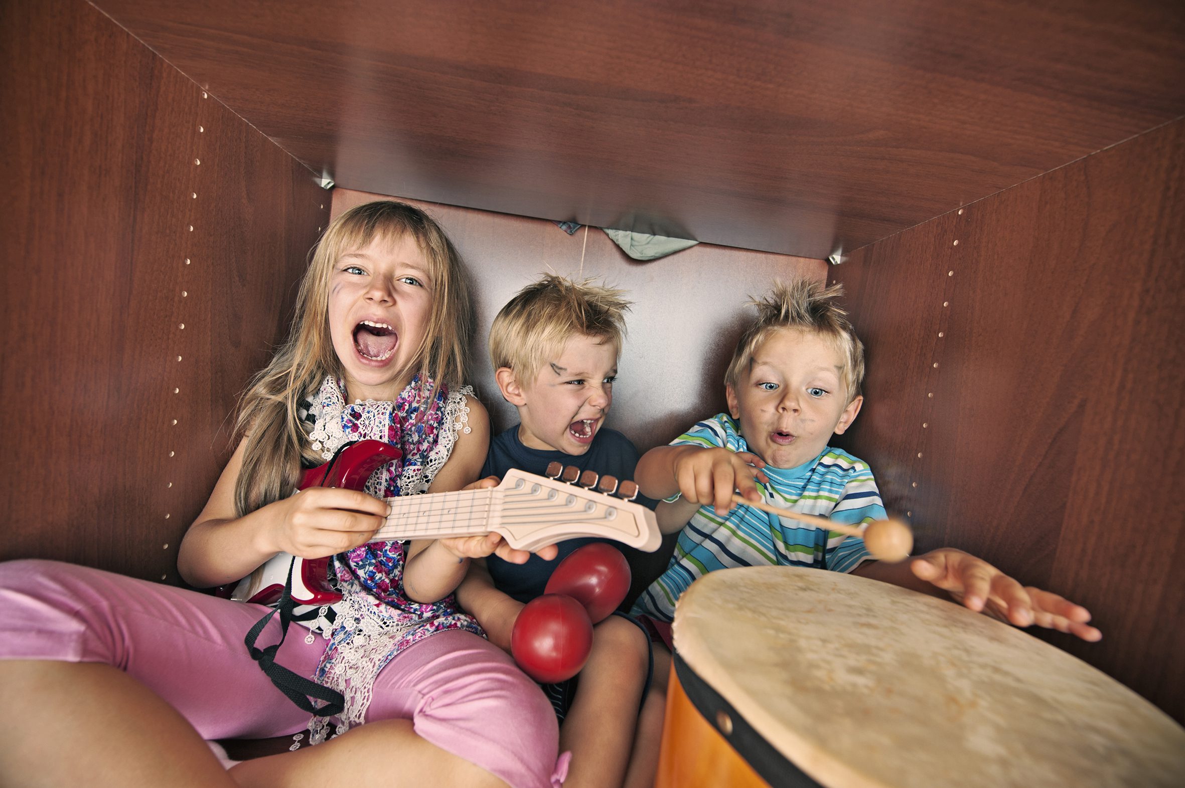 Kinderband spielt Instrumente und singt kreischend im Kleiderschrank.
